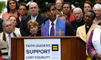 Group photo of faith leaders with one speaking behind a podium with a sign that reads "Faith leaders support LGBTQ Equality" with the HRC equality logo on it.