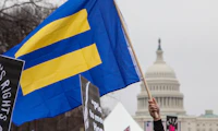 HRC flag with blue background and yellow equal sign flies in front of U.S. Capitol