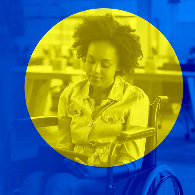 A Black woman reads in a wheelchair.